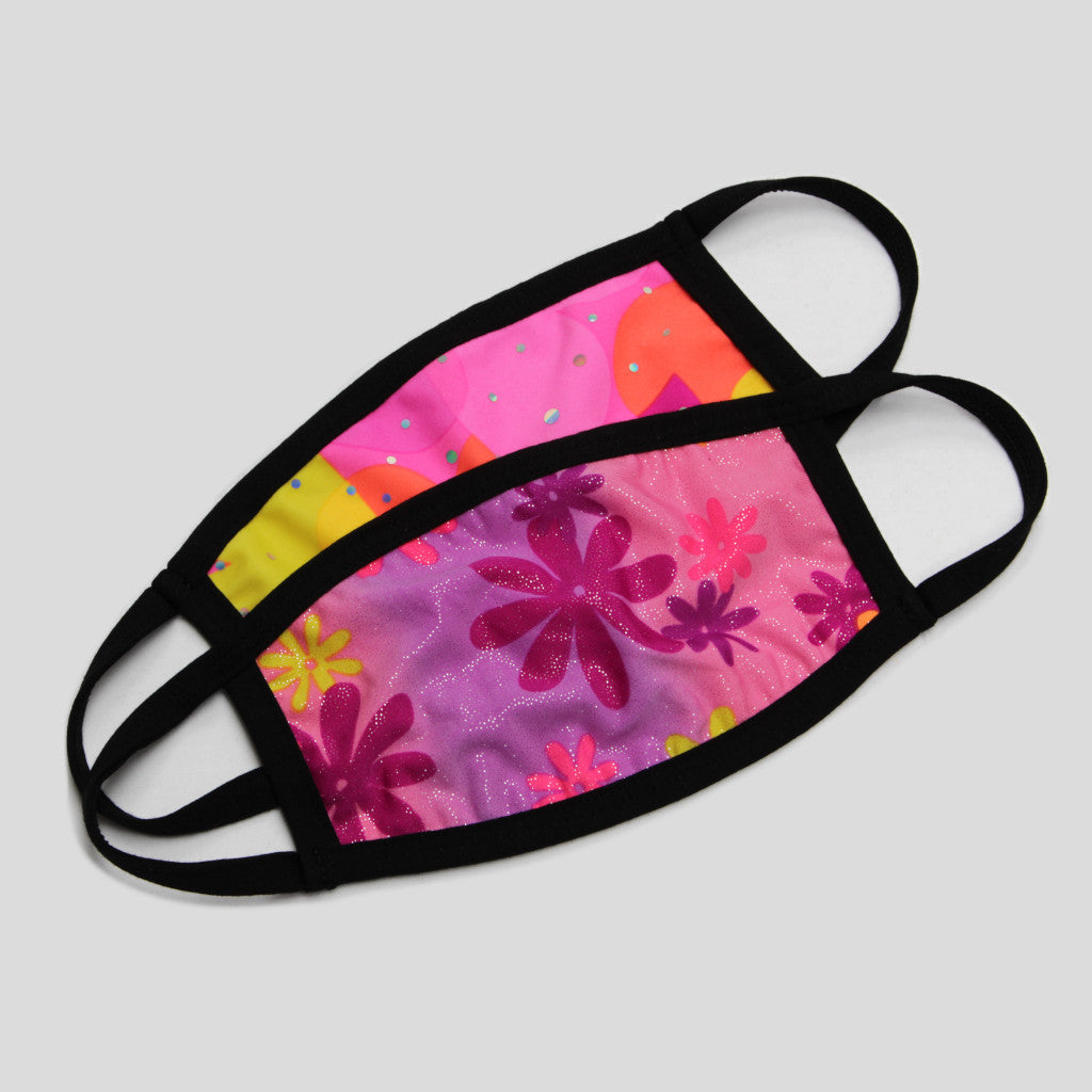 Two children's Australian made fabric face masks where the front mask has a shimmery print with flowers on a pink gradient background