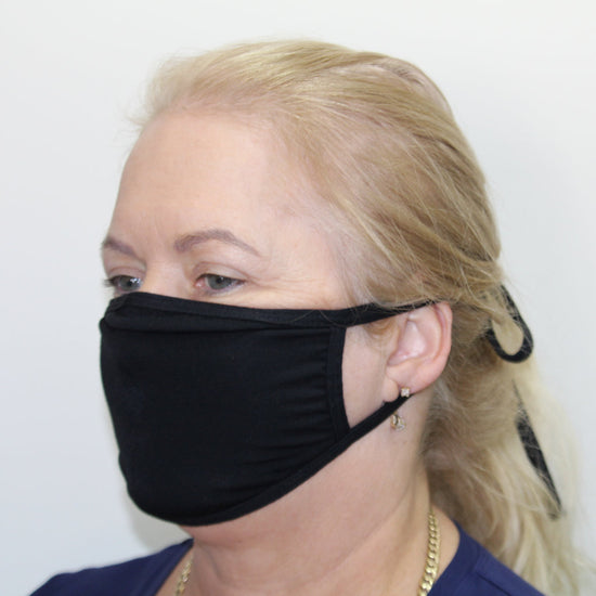 Woman wearing a black Australian made face mask that ties up at the back of the end
